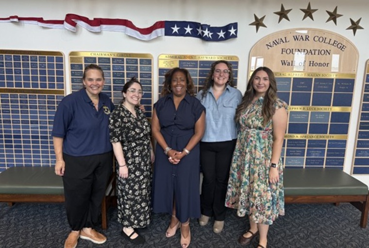 A group of people in front of a wall of names
